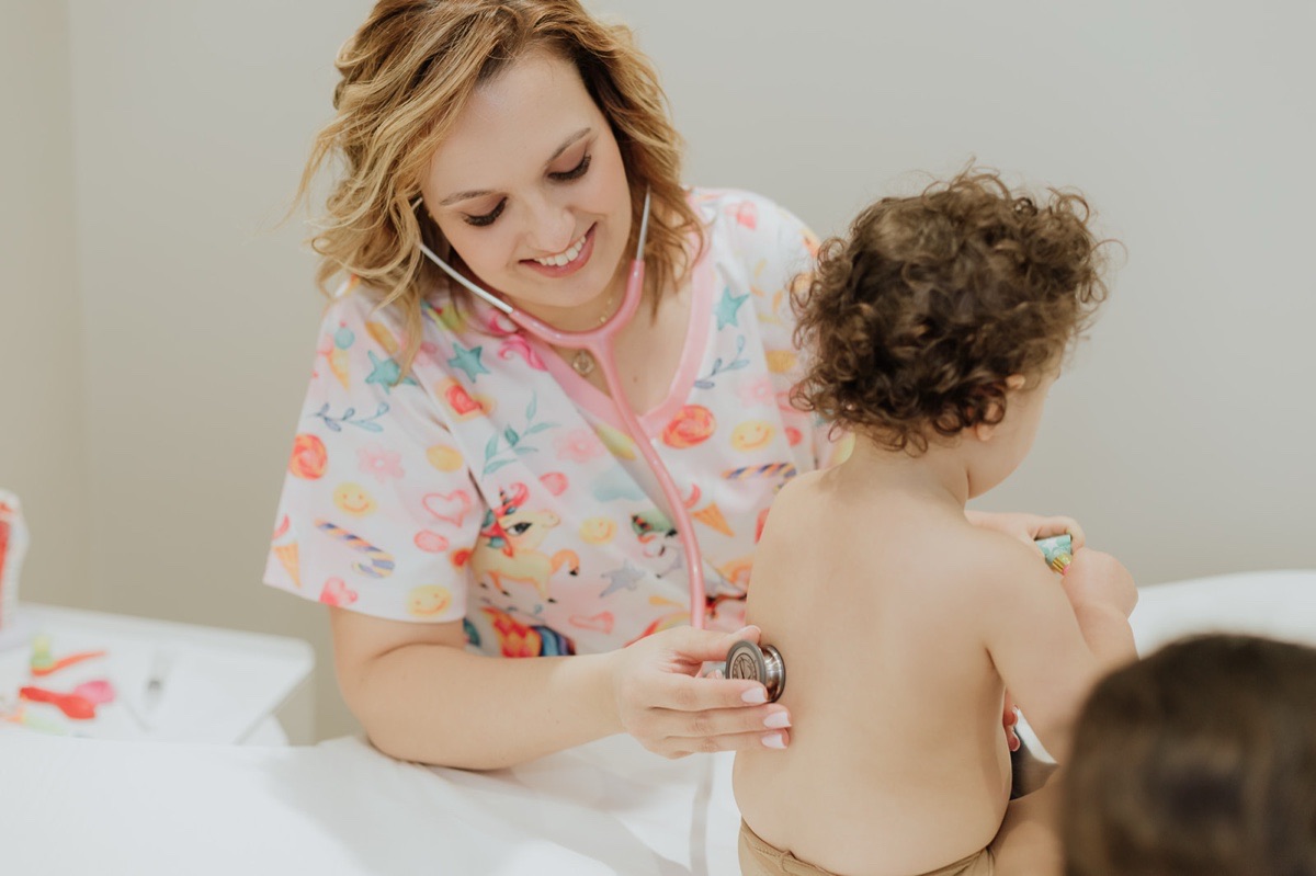 Consulta de Reabilitação Respiratória — enfermeira ausculta criança com estetoscópio